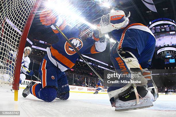 Calvin de Haan of the New York Islanders is knocked into the net by Jonathan Drouin of the Tampa Bay Lightning in Game Four of the Eastern Conference...