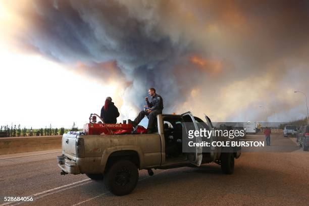 Group trying to rescue animals from Fort McMurray wait at road block on Highway 63 near as smoke rises from a forest fire near Fort McMurray, Alberta...