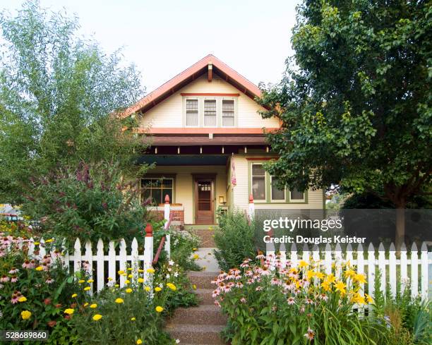 bungalow house with white picket fence - tuinhek stockfoto's en -beelden