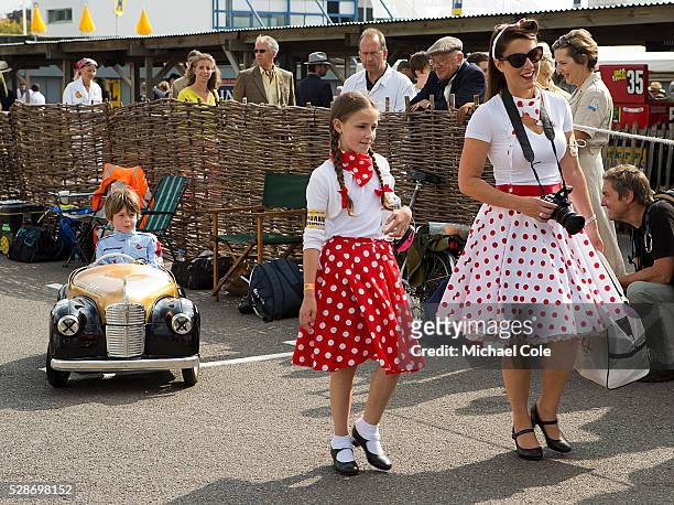 Stylish lady & girl in polka dot skirts & Austin J40 pedal car, The Settrington Cup at the Goodwood Revival Meeting 13th Sept 2014