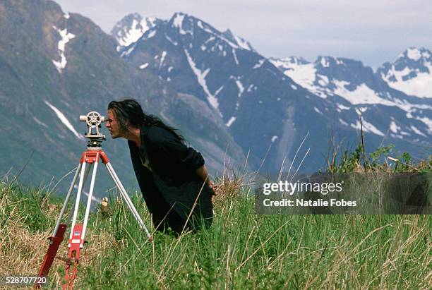 archaeologist using theodolite at excavation site - archeoloog stockfoto's en -beelden