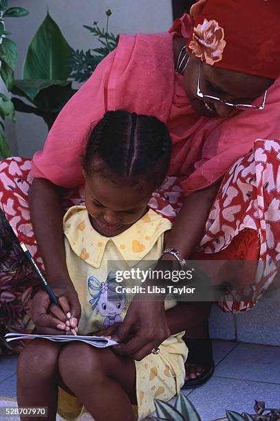 mother helping daughter to write - hargeisa stock pictures, royalty-free photos & images