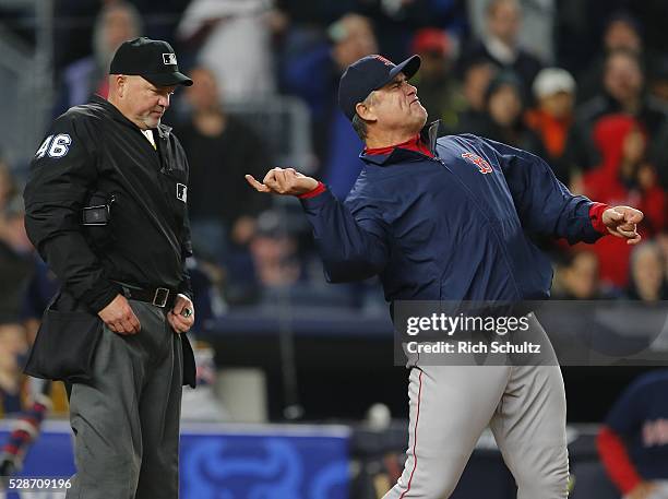 Manager John Farrell of the Boston Red Sox gestures at home plate umpire Ron Kulpa after David Ortiz argued a called strike by home plate umpire Ron...