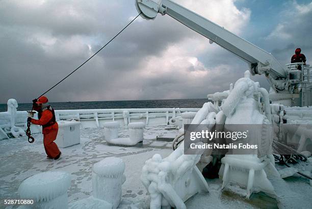 fisherman working on icy ship deck - bering sea fotografías e imágenes de stock