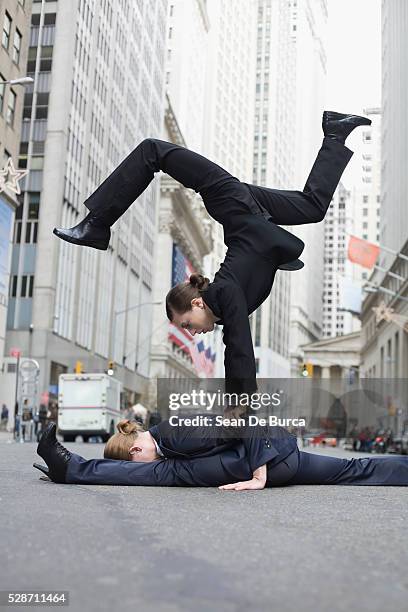 businesswomen balancing in street - businesswoman handstand stock pictures, royalty-free photos & images