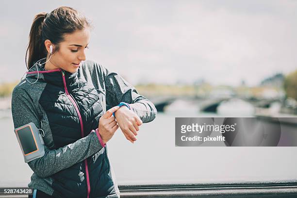 sports woman checking her tech watch - pedometer stock pictures, royalty-free photos & images