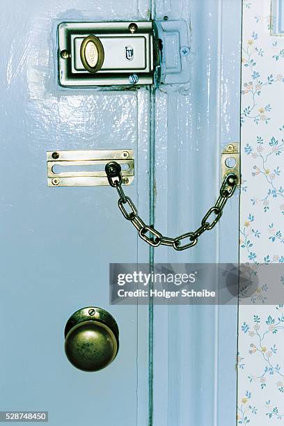 door with security lock and door chain - slot beveiligingsapparatuur stockfoto's en -beelden