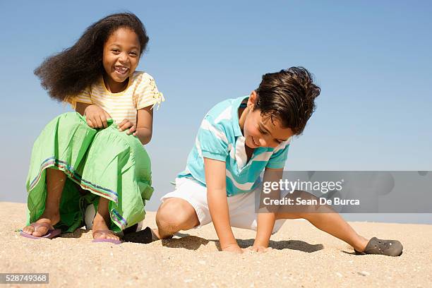 kids playing on the beach - digging beach photos et images de collection