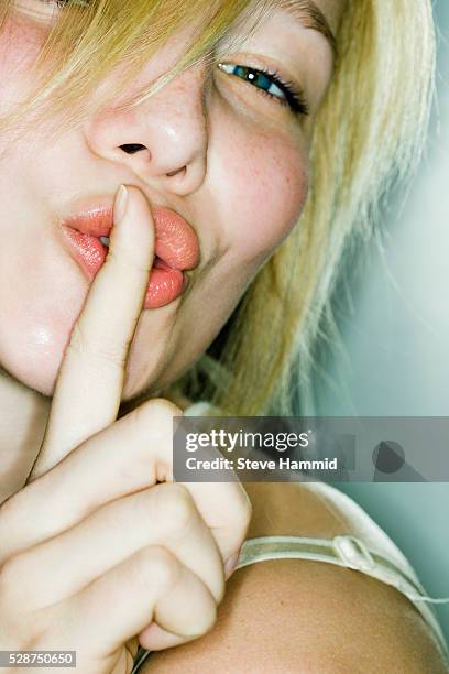 young woman with hands on lips - woman with finger on lips stock pictures, royalty-free photos & images