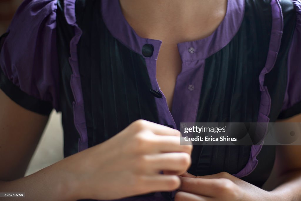 Young Woman Unbuttoning Blouse