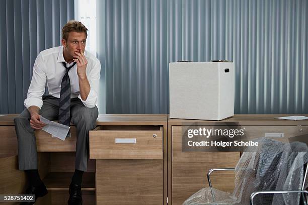 unemployed businessman packing in empty office - downsizing unemployment bildbanksfoton och bilder