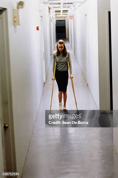 woman with crutches in corridor - elastic bandage stockfoto's en -beelden