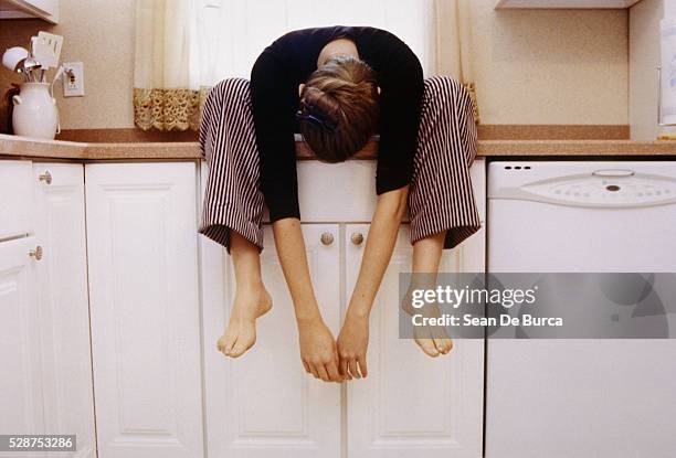 young woman sitting on kitchen cupboard - boring stock pictures, royalty-free photos & images