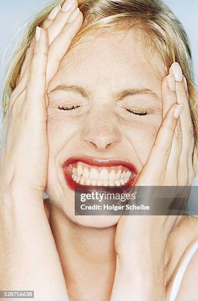 young woman with contorted face - serrare i denti foto e immagini stock