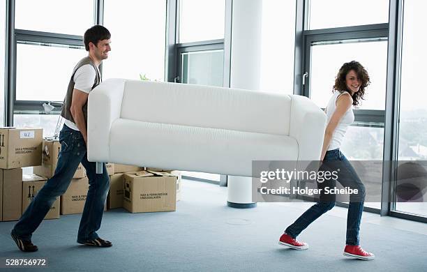 couple carrying sofa - carrying photos et images de collection