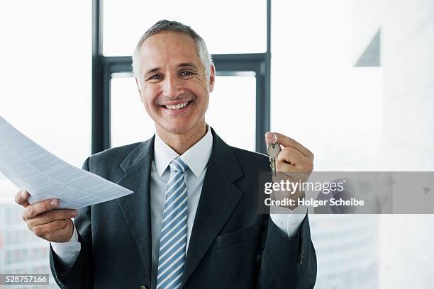 real estate agent holding keys and deed - corretor de imóveis - fotografias e filmes do acervo