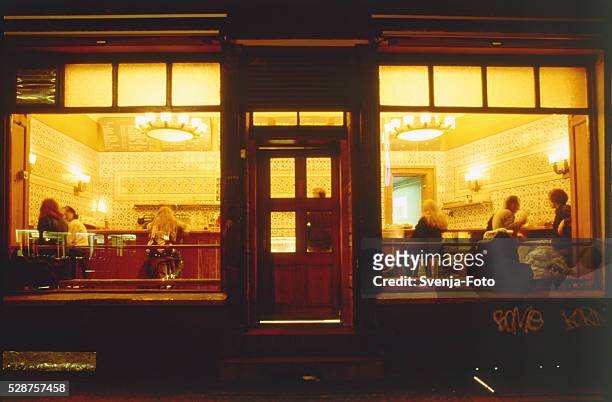 customers in an illuminated restaurant - berlin cafe stock pictures, royalty-free photos & images