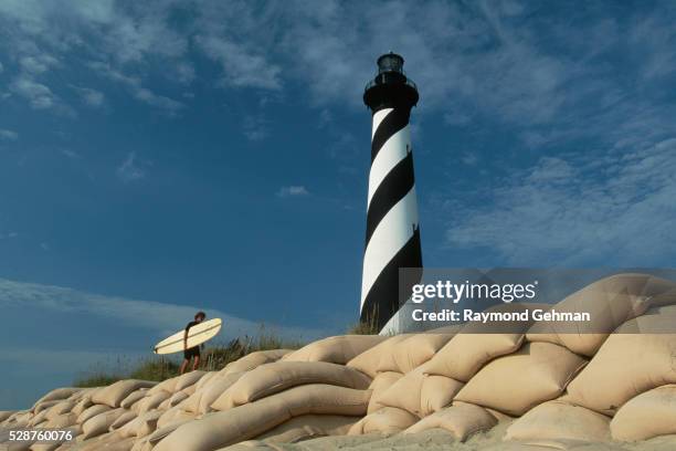 surfer walking near lighthouse - cape hatteras stock-fotos und bilder