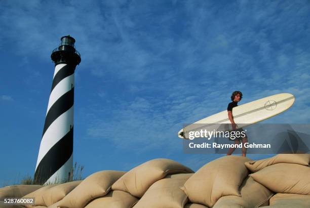 surfer walking near lighthouse - cape hatteras stock-fotos und bilder