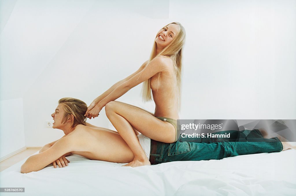 Young couple fooling around in bed