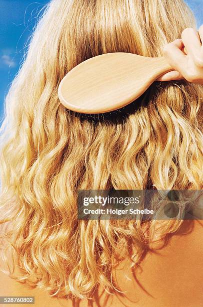 woman brushing her long blonde hair - cepillo para el cabello fotografías e imágenes de stock