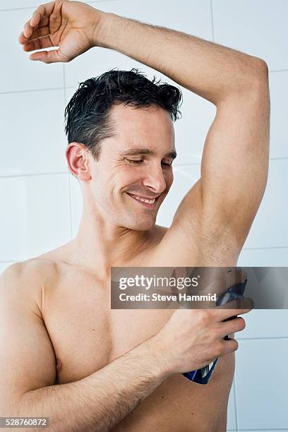 man applying deodorant - deodorant stock-fotos und bilder