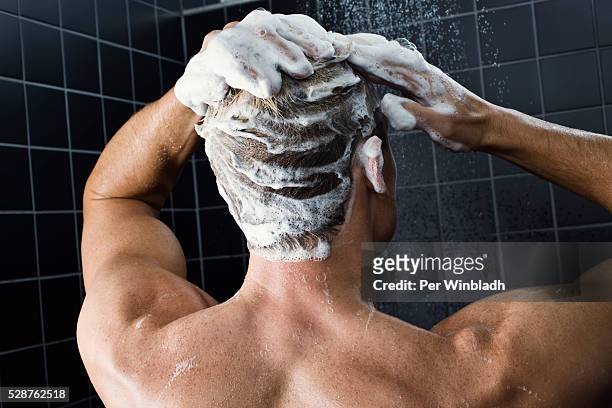 man taking a shower - shampoo photos et images de collection