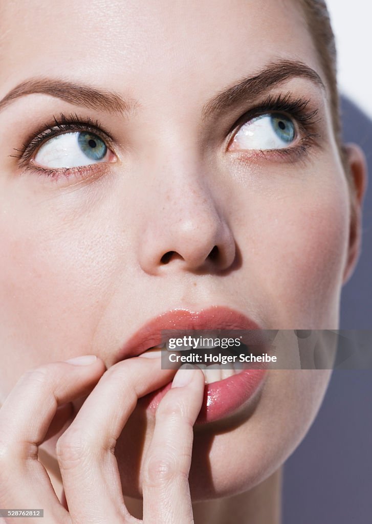 Beautiful woman with fingers in mouth