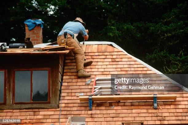 worker applying cedar shingles to roof - cedar shingles stock pictures, royalty-free photos & images
