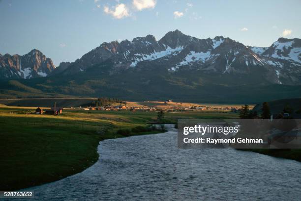 snake river leading to town at foot of mountains - snake river stock-fotos und bilder