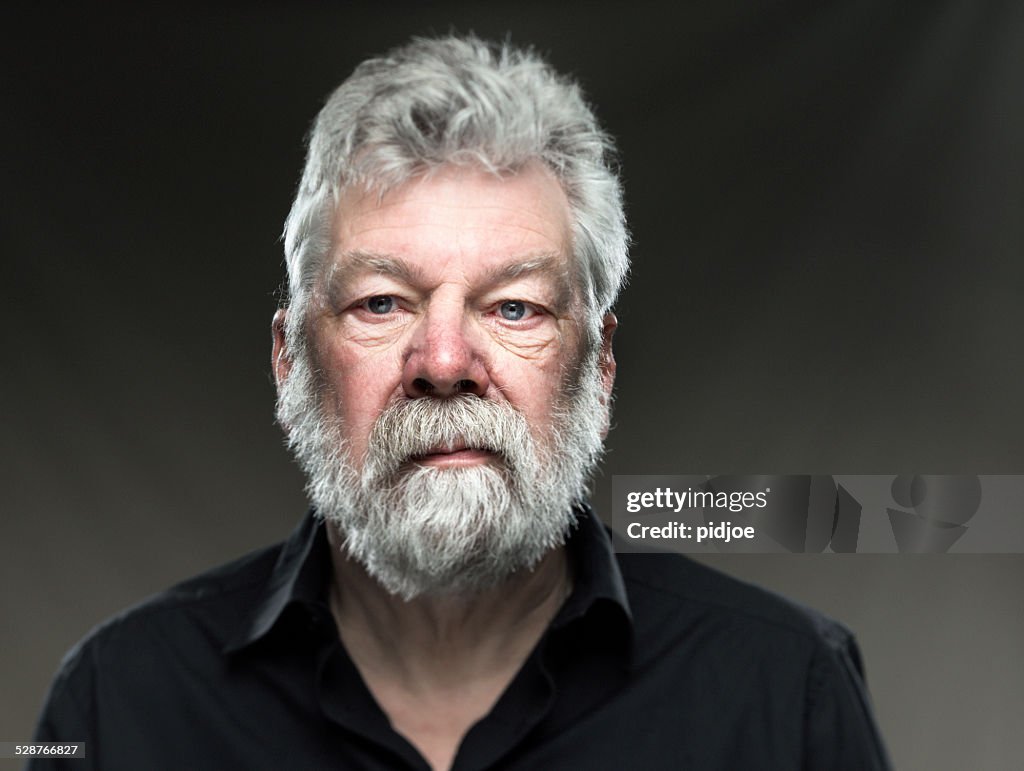 Porträt echte Mann mit Bart, schaut gerade in die Kamera.