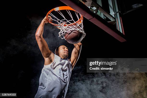 performing a slam dunk - jump shot basketball stock pictures, royalty-free photos & images