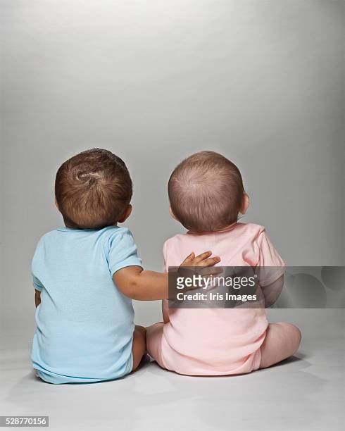 pink and blue babies together - cute baby studioshot stock-fotos und bilder