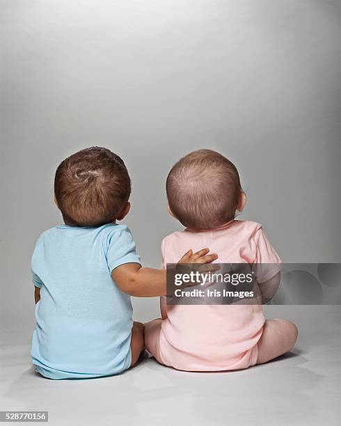 pink and blue babies together - baby girls foto e immagini stock