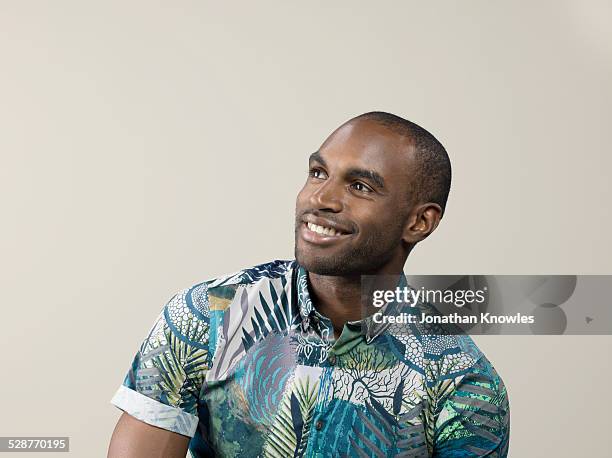 dark skinned male, looking away, smiling - black shirt fashion stock pictures, royalty-free photos & images