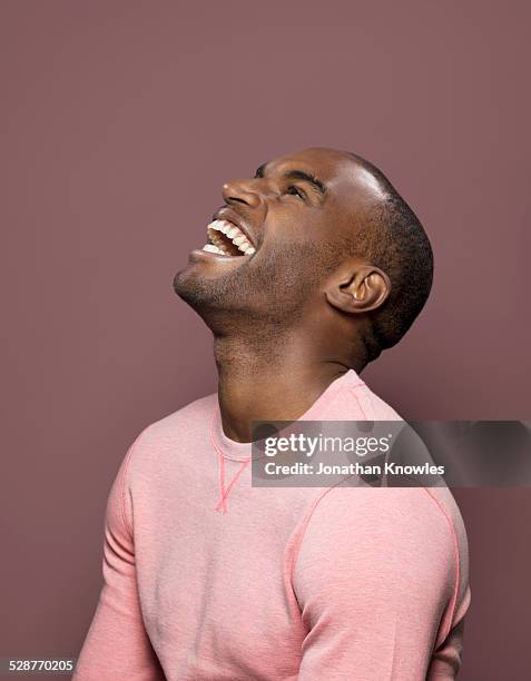dark skinned looking up, laughing - pink shirt isolated stock pictures, royalty-free photos & images