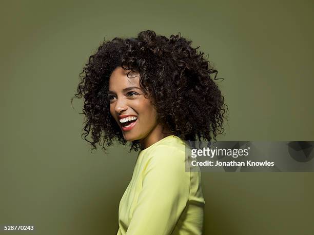 side portrait of a dark skinned female, laughing - curly hair - fotografias e filmes do acervo