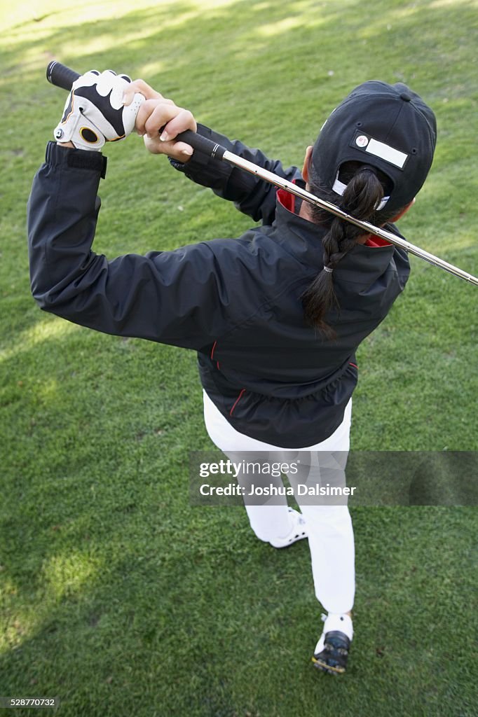 Woman Swinging a Golf Club