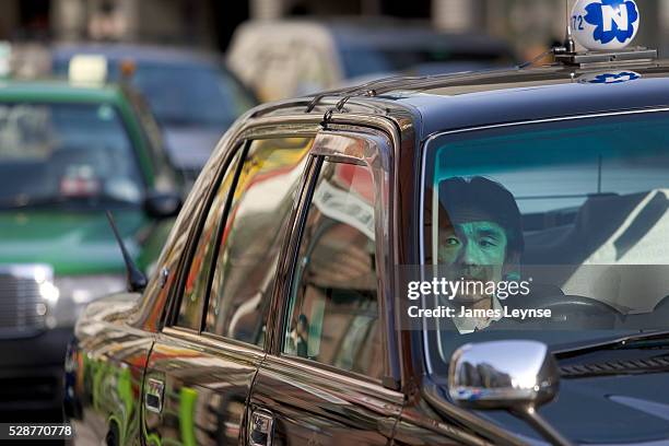 Taxi driver in Tokyo. Drivers in Japan, like Great Britian, drive on the left hand side of the road.