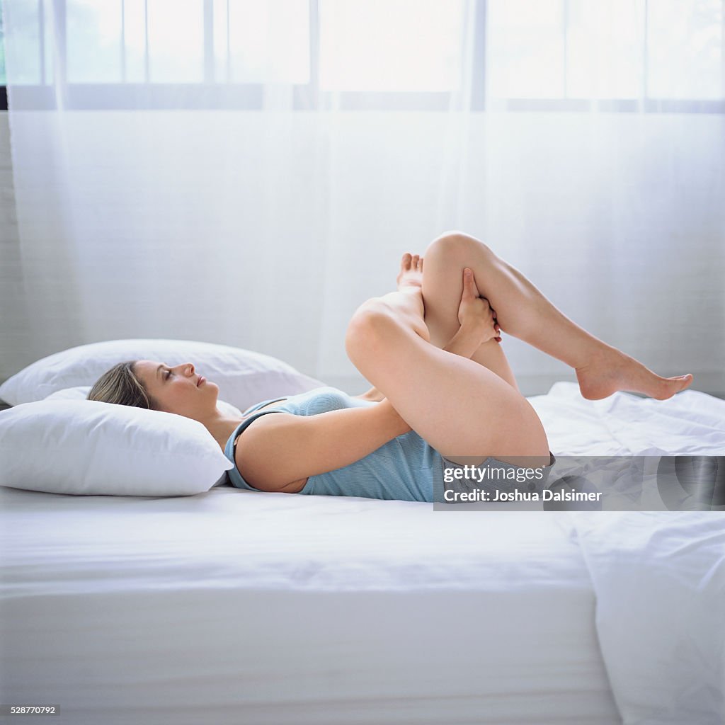 Woman stretching in bed