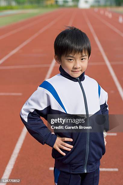 young boy on running track - boy tracksuit stock pictures, royalty-free photos & images