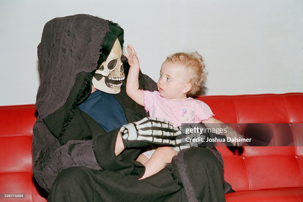 Person in costume holding baby