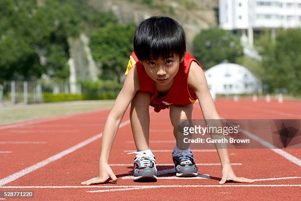 young boy ready to race - boy running track stock pictures, royalty-free photos & images