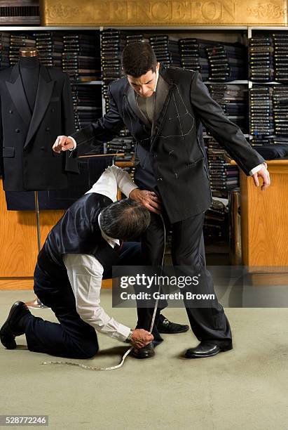 tailor making customer uncomfortable as he measures inseam - tailor measuring stock pictures, royalty-free photos & images