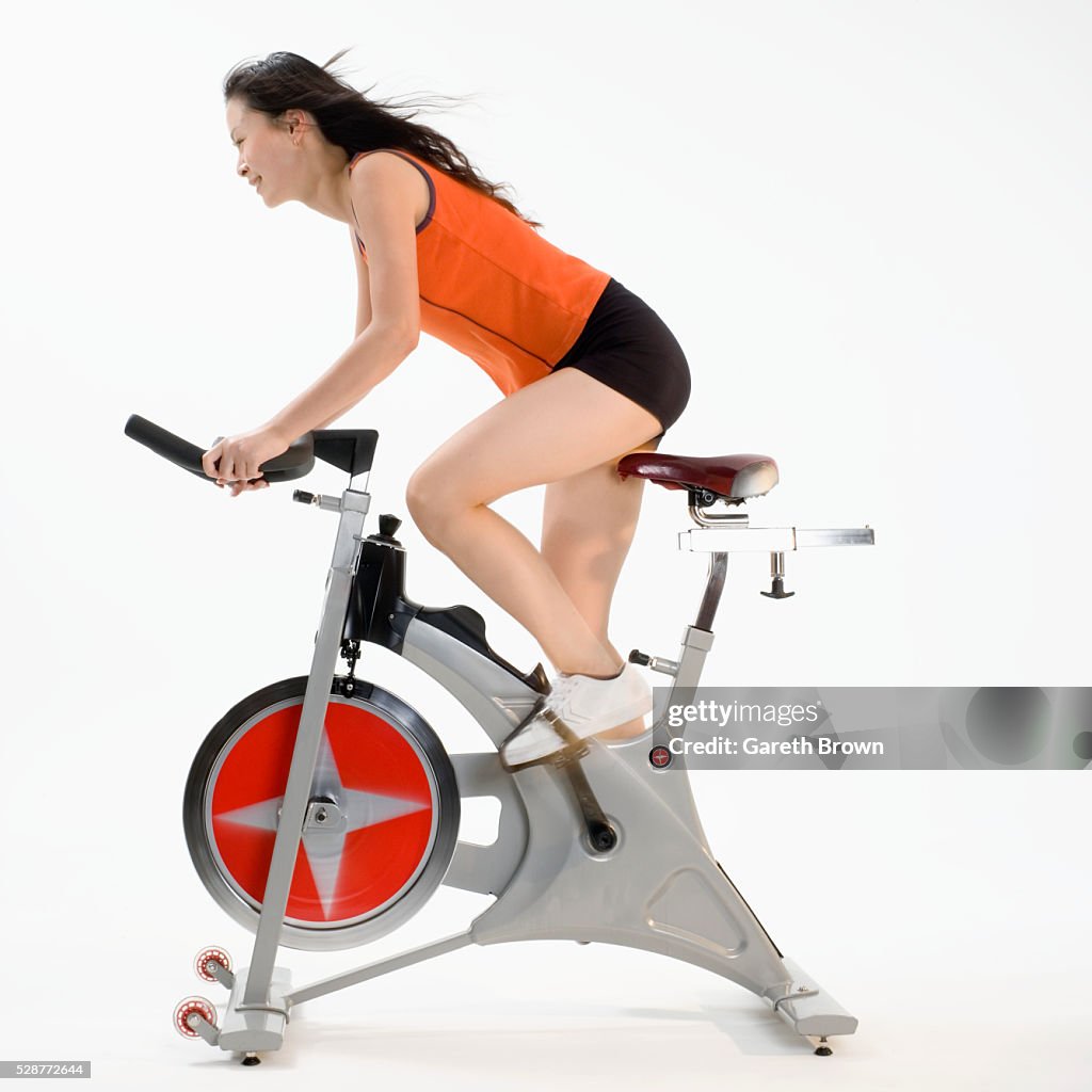 Young Woman Riding Exercise Bicycle