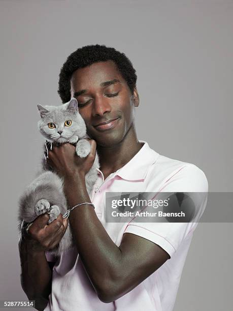 man cuddling cat - holding cat stock-fotos und bilder