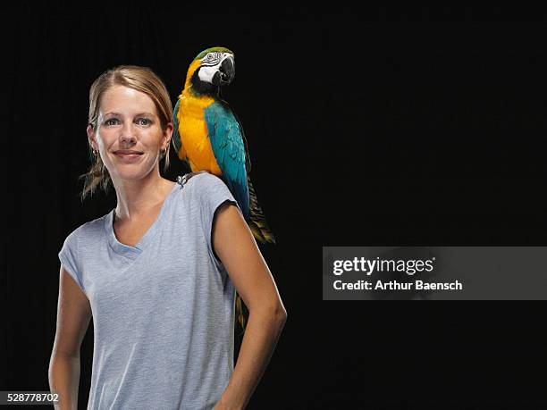 parrot sitting on woman's shoulder - parrot shoulder stock pictures, royalty-free photos & images