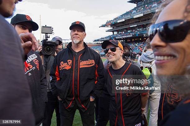 Vocalist James Hetfield, drummer Lars Ulrich and guitarist Kirk Hammett of Metallica talks with San Francisco Giants outfielder Gregor Blanco before...