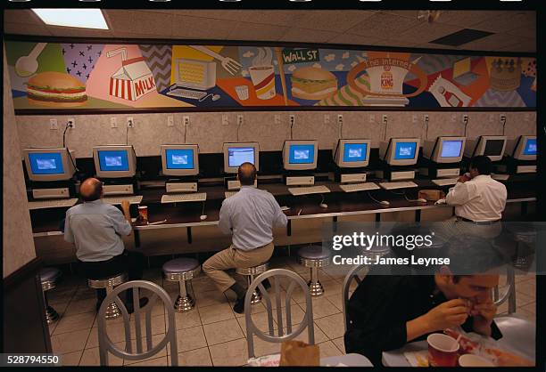 Several businessmen working on computers at a Burger King in Manhattan that offers internet access with a meal.