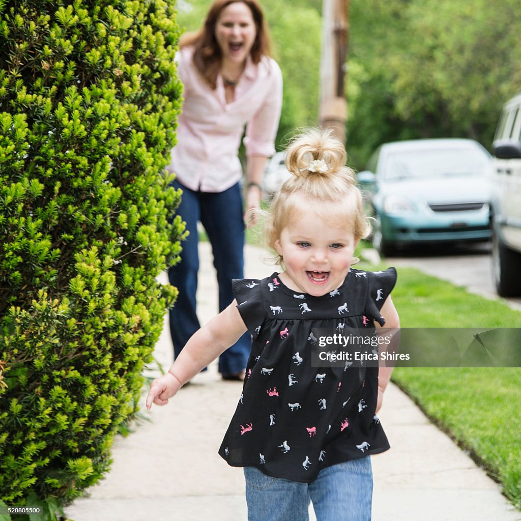 Girl (12-23 months) running away from mother